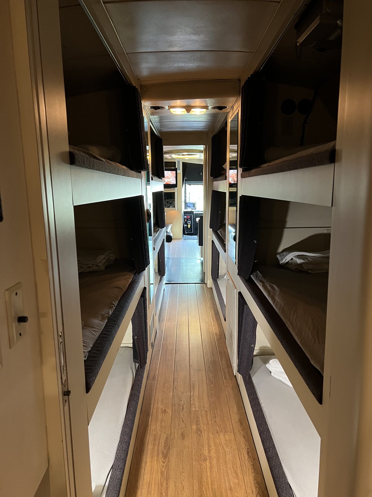 Coach bunk hallway with flip-down TVs